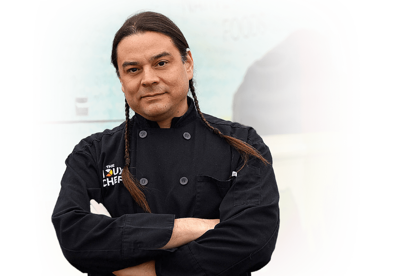 Native American man in chef coat with The Sioux Chef logo